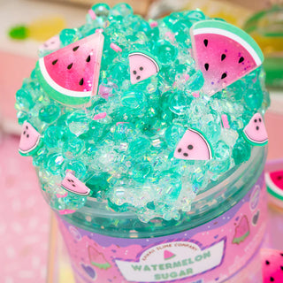 Close-up of a jar of watermelon-themed slime with watermelon slice charms and bingsu beads in the slime.