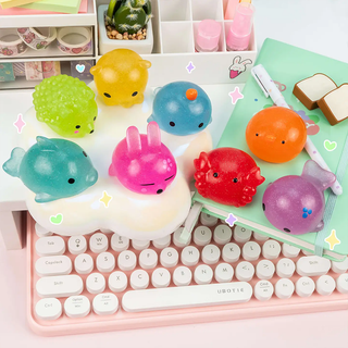 Colorful squishy toys on a keyboard with a light background.