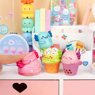 Colorful snack-themed axolotl squishy toys on a shelf with a hand squishing one of them.