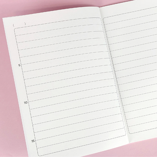 Open notebook with lined pages on a pink background